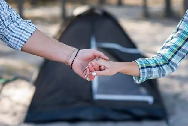 couple holding hands blurred tent